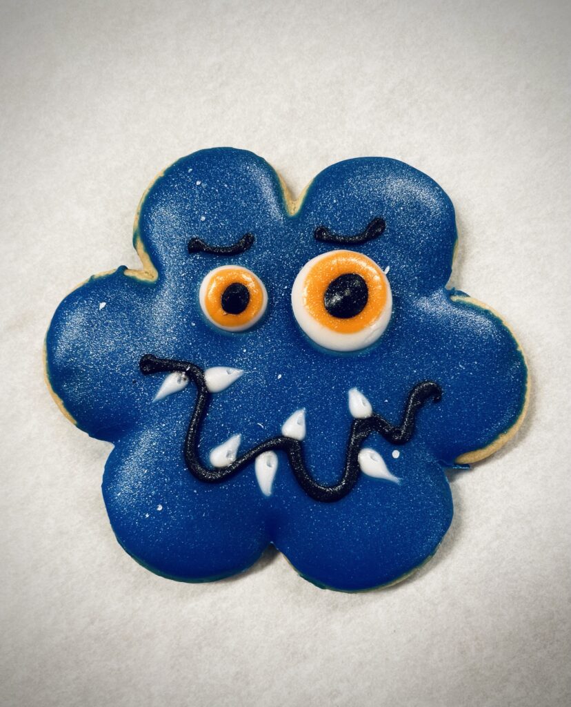 Flower shaped blue treat with eyes, eyebrows, an wavy mouth