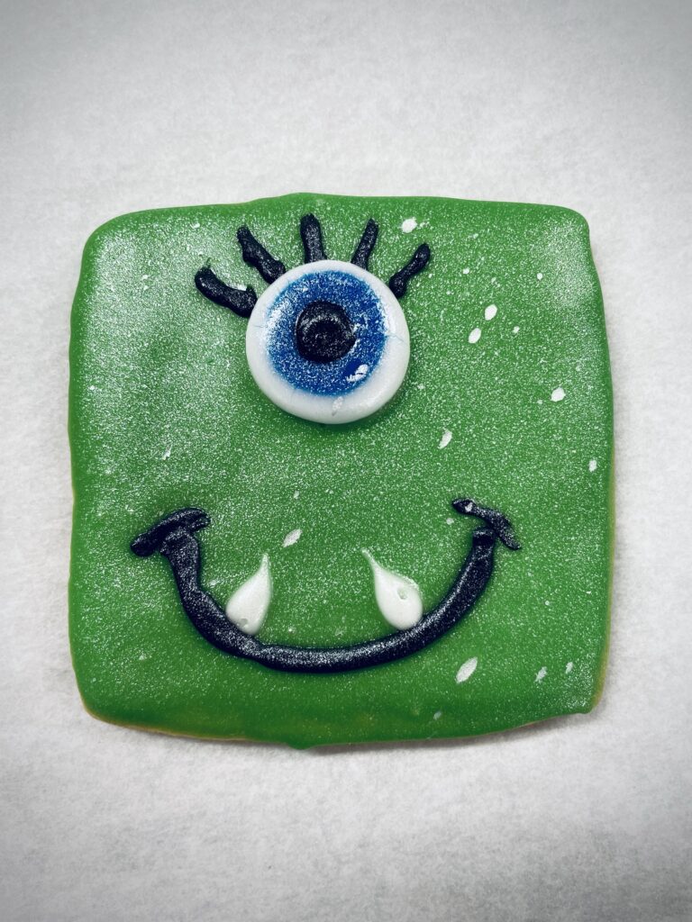Green treat with eyes and smiling mouth