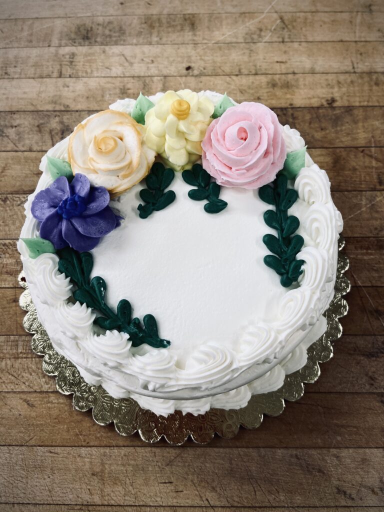 Cake with blue, light orange, pink flowers design